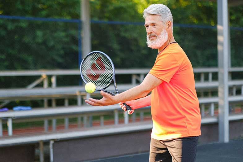 Aged Active Tennis Player with Ball and Racket