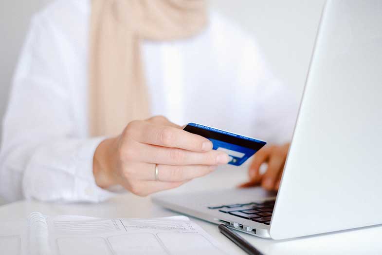 Person in White Long Sleeve Shirt Holding Credit Card