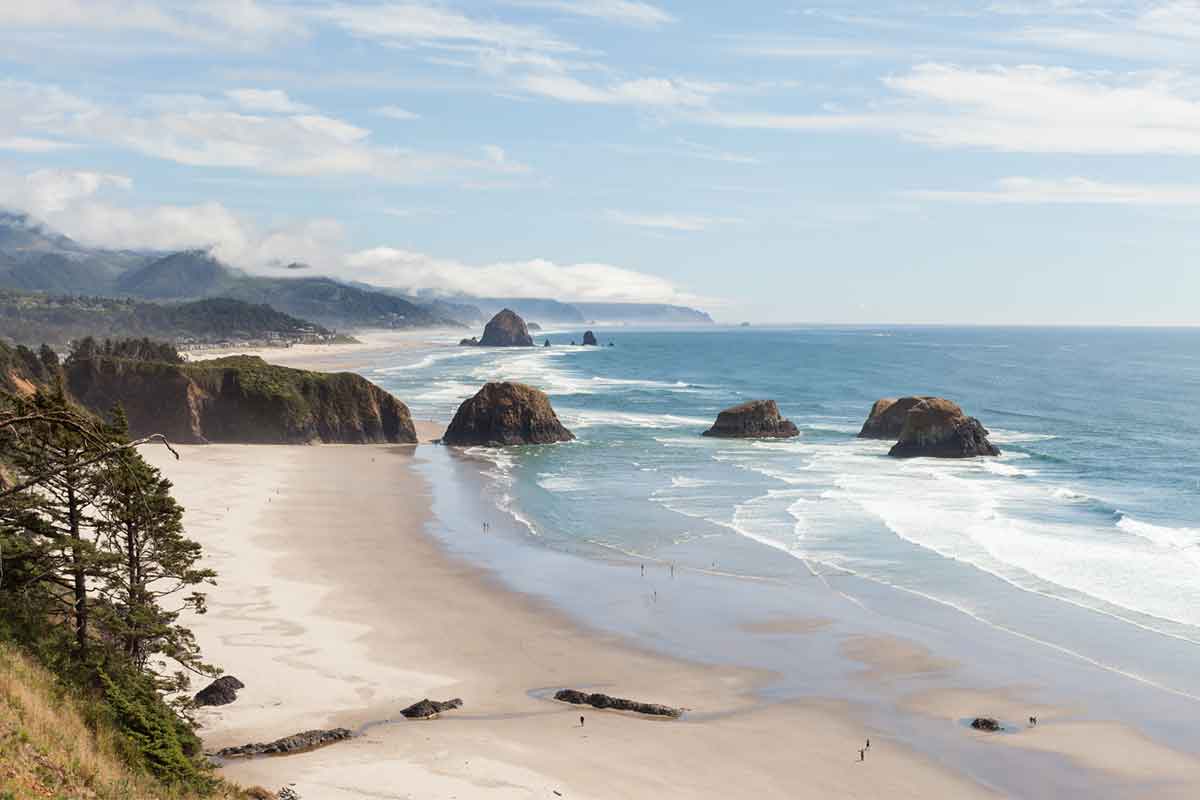 A view of Cannon Beach with the shore silhouetted in the background